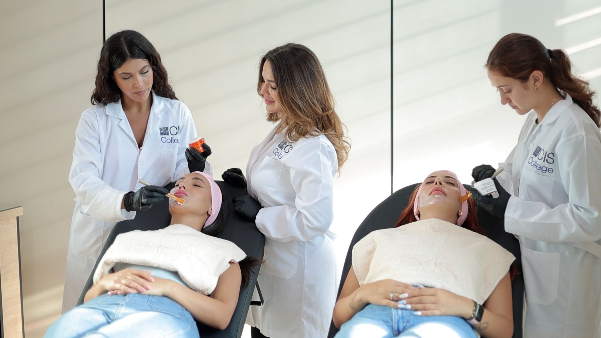 Cosmetology students performing facial treatments during practical training.