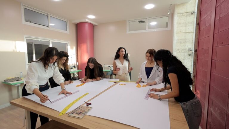 Design students working together on sketches around a large table.