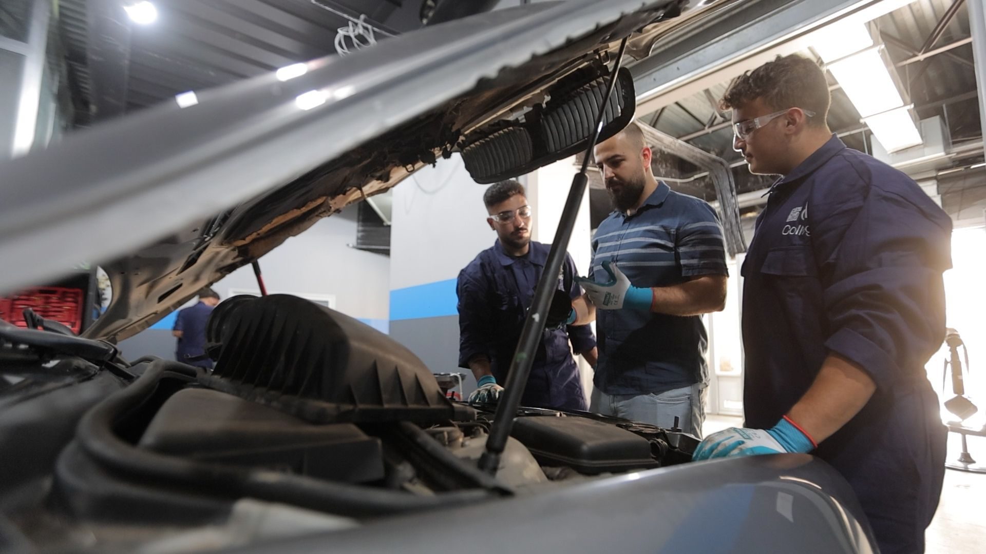 Mechanics with protective gloves working on engine components.